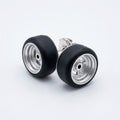 A pair of stud earrings designed to look like miniature airplane landing gear wheels, featuring black rubber tires and silver metallic rims, set against a clean white background.