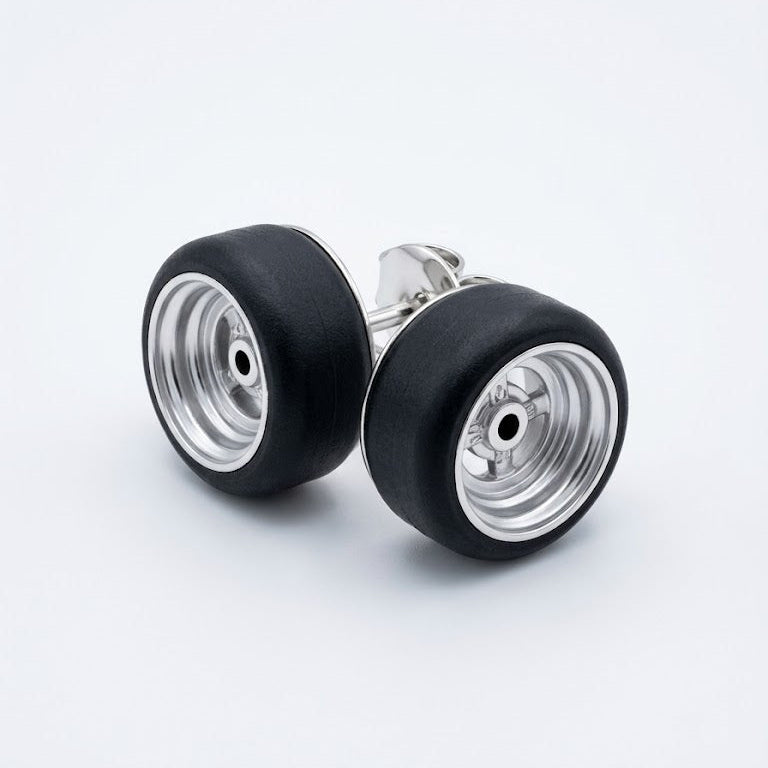 A pair of stud earrings designed to look like miniature airplane landing gear wheels, featuring black rubber tires and silver metallic rims, set against a clean white background.