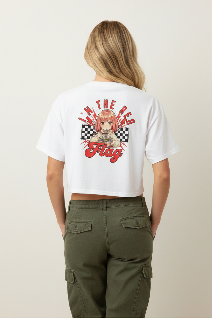 A woman viewed from behind wearing a white cropped T-shirt with a large anime-style graphic and red text on the back, paired with olive green cargo pants, against a plain light beige studio background.